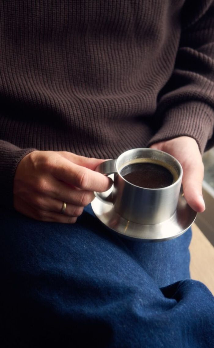 Mand der holder kaffekop i stål